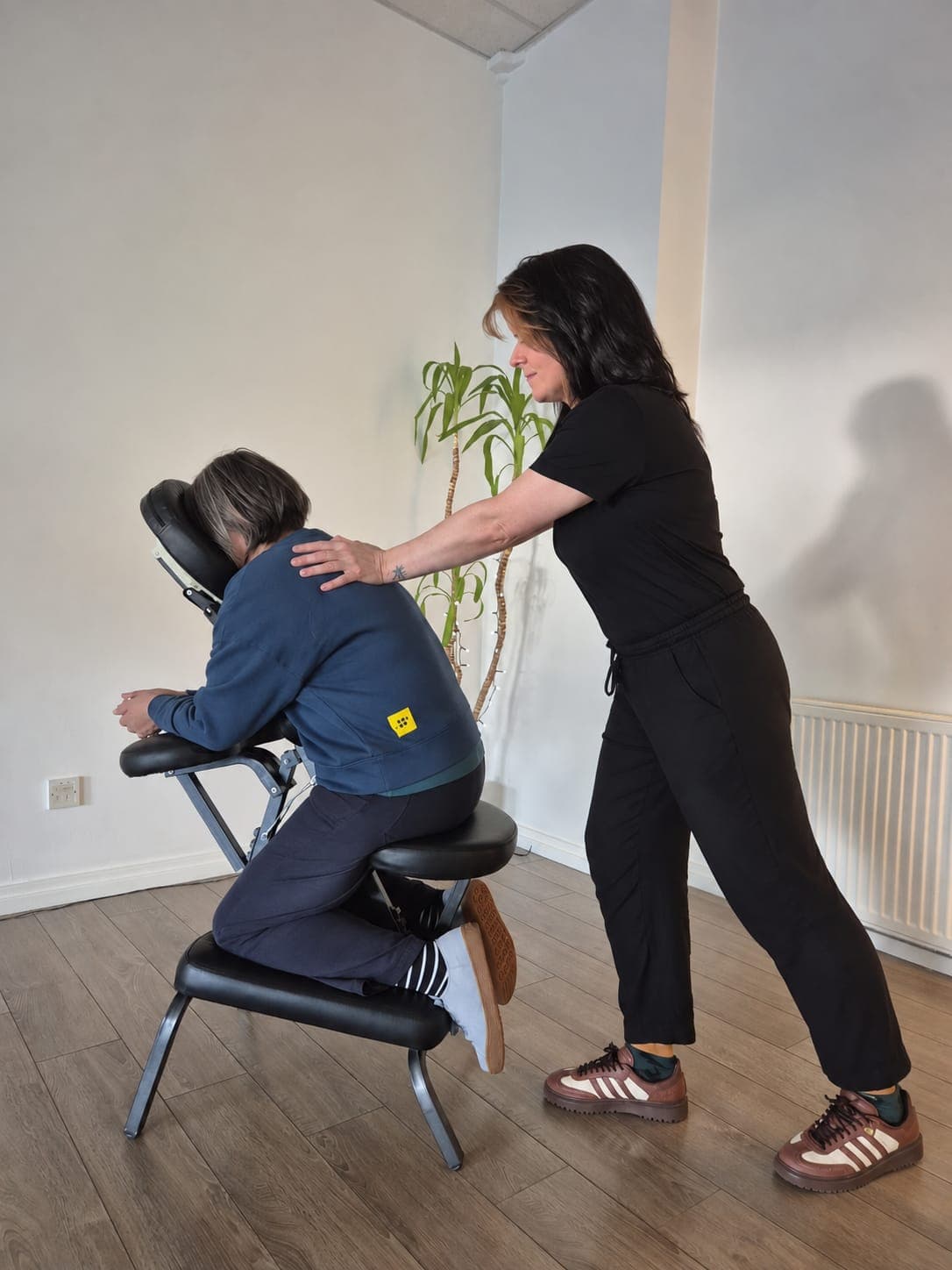 Therapist providing seated chair massage for workplace wellbeing
