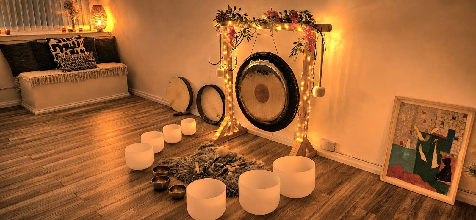 Gong lit with fairy lights beside crystal and Tibetan singing bowls, ready for a Glasgow sound bath